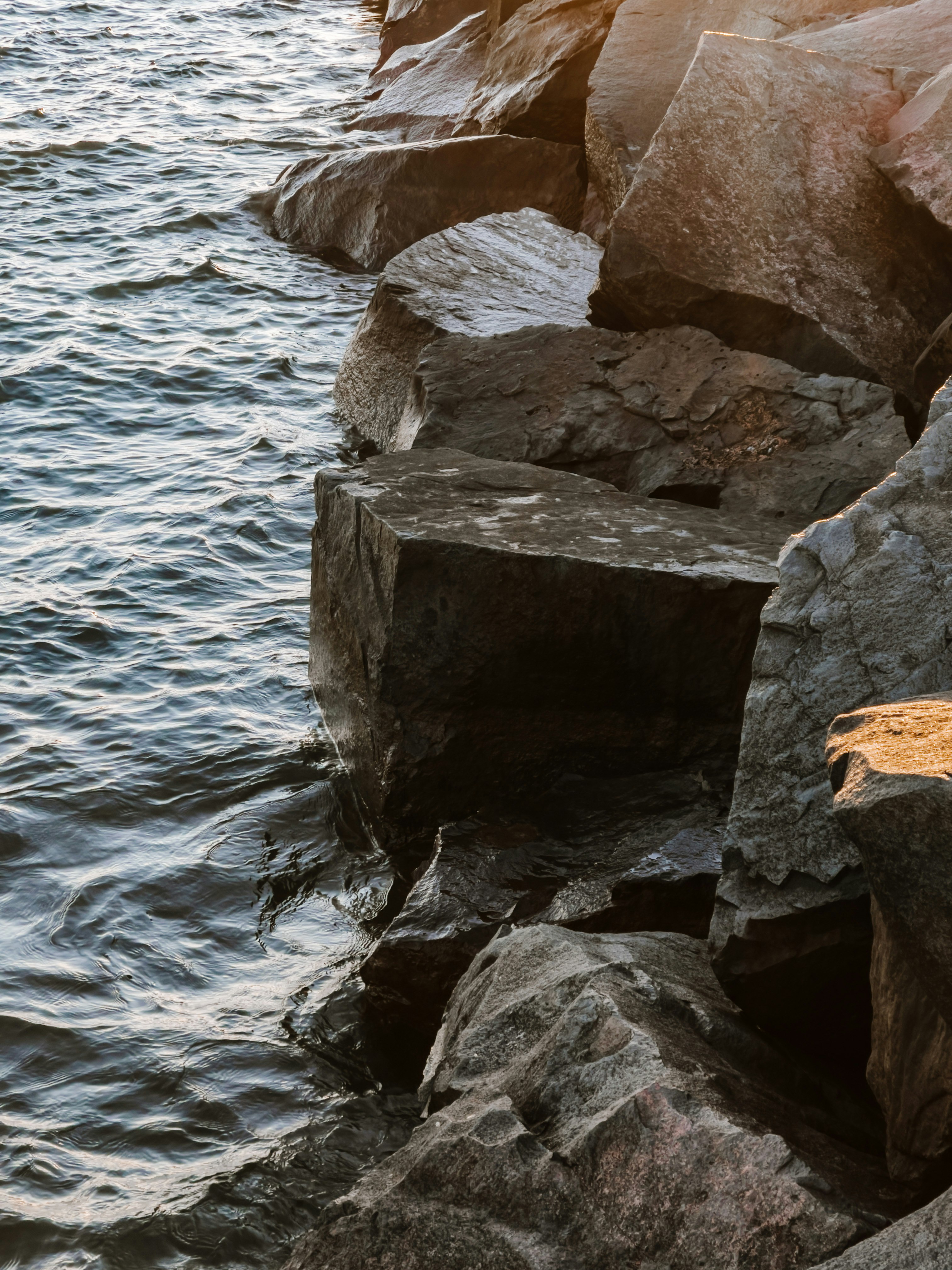 brown rock formation beside body of water during daytime